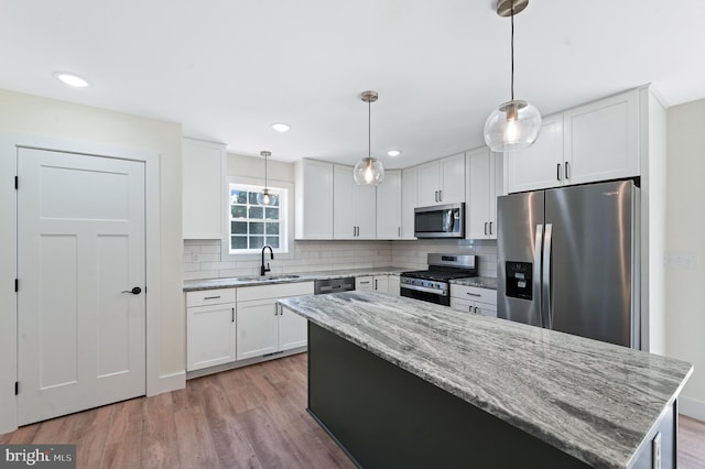 kitchen featuring white cabinets, sink, appliances with stainless steel finishes, and light hardwood / wood-style flooring