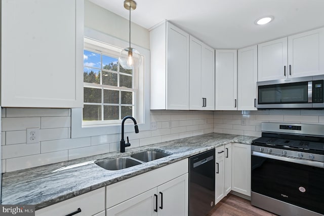 kitchen with light stone countertops, sink, white cabinets, and appliances with stainless steel finishes