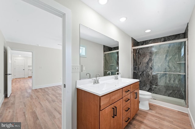 bathroom with hardwood / wood-style floors, vanity, and an enclosed shower