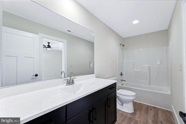 full bathroom featuring vanity,  shower combination, ceiling fan, hardwood / wood-style flooring, and toilet