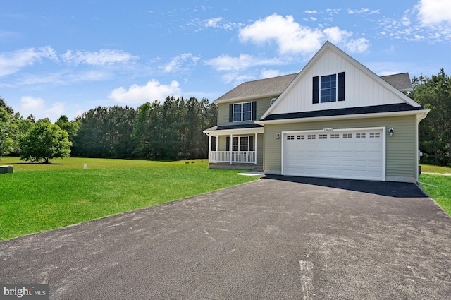 view of front of home with a front lawn, covered porch, and a garage