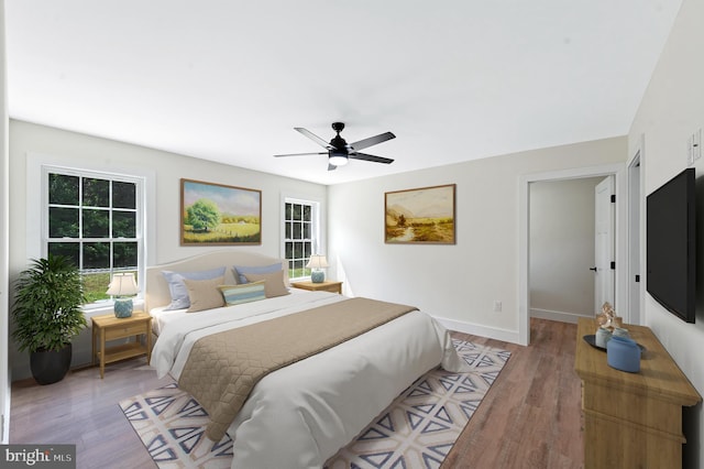 bedroom with ceiling fan and light hardwood / wood-style flooring