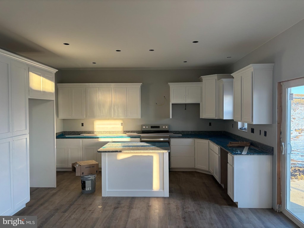 kitchen featuring a kitchen island, dark hardwood / wood-style floors, white cabinets, and stainless steel range with electric stovetop