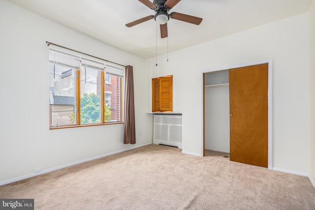 unfurnished bedroom featuring carpet, ceiling fan, and a closet