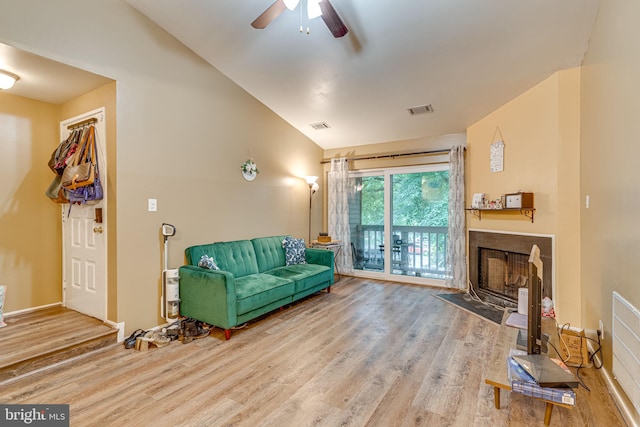 living room with wood-type flooring, ceiling fan, and vaulted ceiling