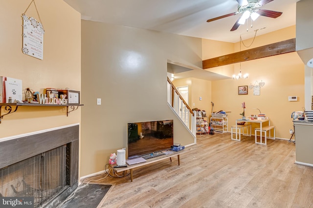 living room with ceiling fan, beam ceiling, and wood-type flooring