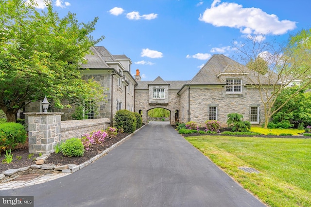 french country style house featuring a front yard