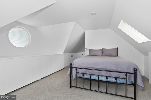 carpeted bedroom featuring vaulted ceiling with skylight