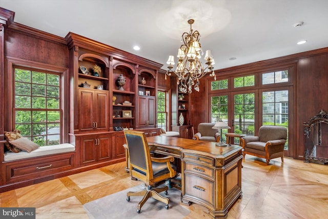 office space featuring light parquet floors, an inviting chandelier, ornamental molding, and wood walls