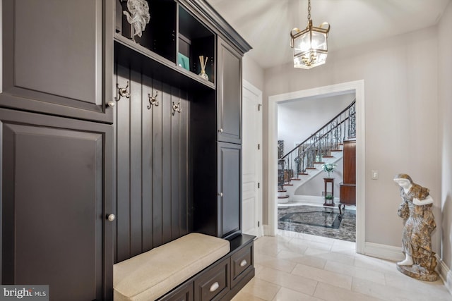 mudroom with light tile patterned floors and an inviting chandelier