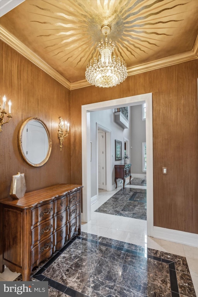 entrance foyer with ornamental molding, a wall unit AC, wooden walls, and a notable chandelier