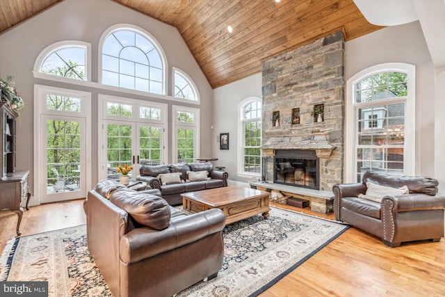 living room with light wood-type flooring, wooden ceiling, high vaulted ceiling, and a healthy amount of sunlight