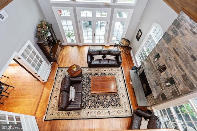 living room with french doors, wood-type flooring, and a high ceiling