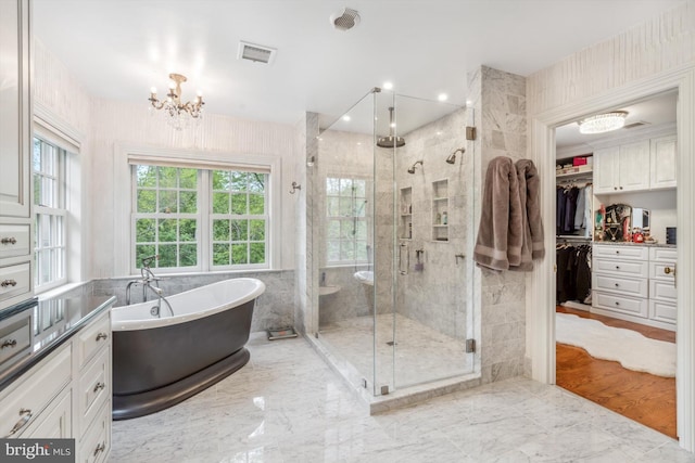 bathroom with a chandelier, hardwood / wood-style flooring, and separate shower and tub