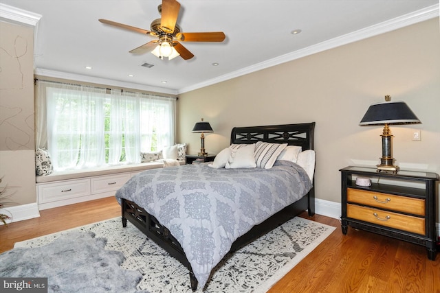 bedroom with ceiling fan, crown molding, and dark wood-type flooring