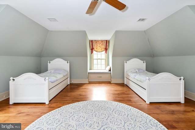 bedroom with ceiling fan, light wood-type flooring, and vaulted ceiling