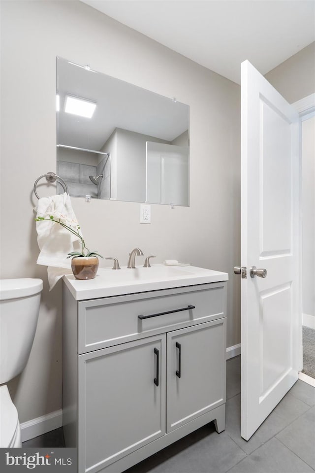 bathroom with tile patterned flooring, vanity, and toilet