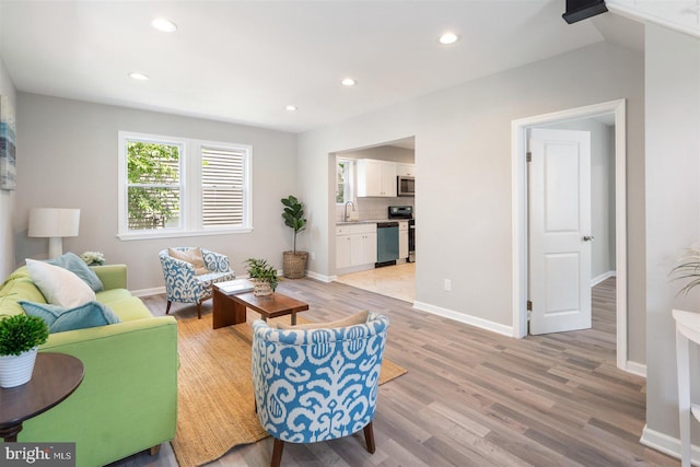 living room featuring light hardwood / wood-style flooring and sink