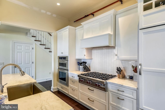 kitchen featuring appliances with stainless steel finishes, white cabinetry, backsplash, and dark hardwood / wood-style flooring