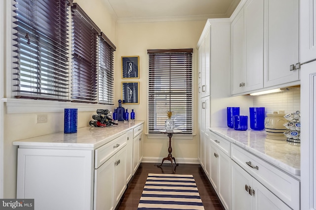 kitchen featuring white cabinetry, ornamental molding, tasteful backsplash, and light stone countertops