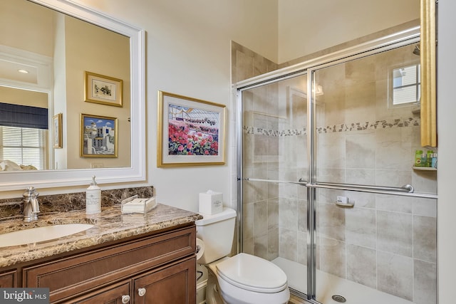 bathroom with an enclosed shower, toilet, and vanity with extensive cabinet space