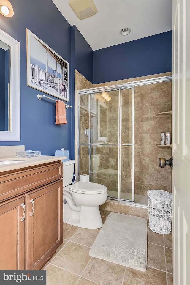 bathroom featuring walk in shower, tile flooring, vanity, and toilet