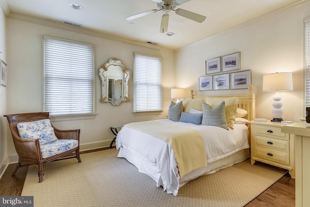 bedroom with light hardwood / wood-style floors, ornamental molding, and ceiling fan