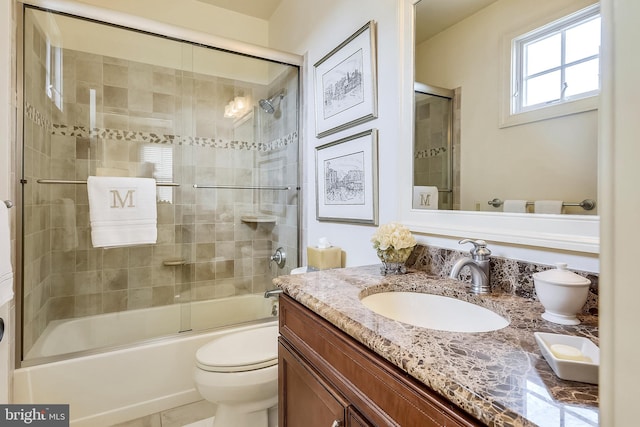 full bathroom with shower / bath combination with glass door, vanity, and toilet