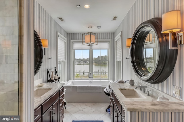 bathroom featuring a bathtub, tile flooring, vanity, and a water view