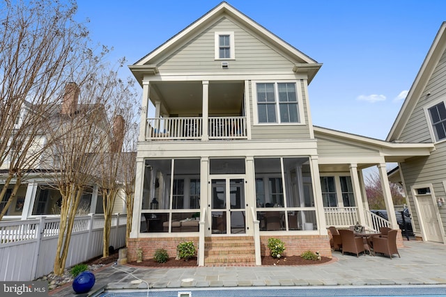 back of house featuring a sunroom and a balcony