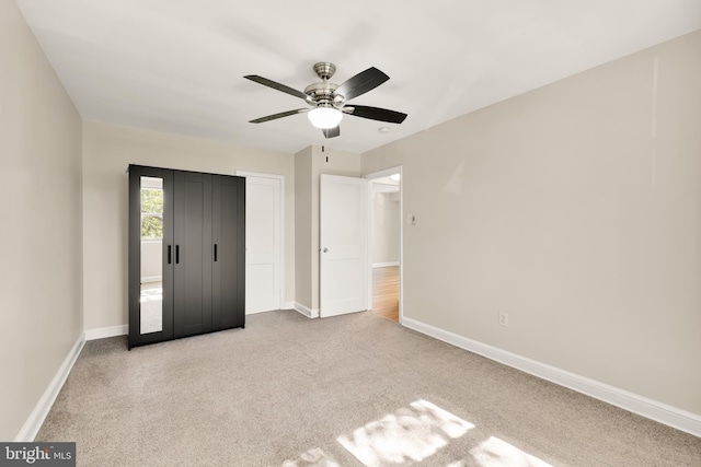 unfurnished bedroom featuring ceiling fan and light colored carpet