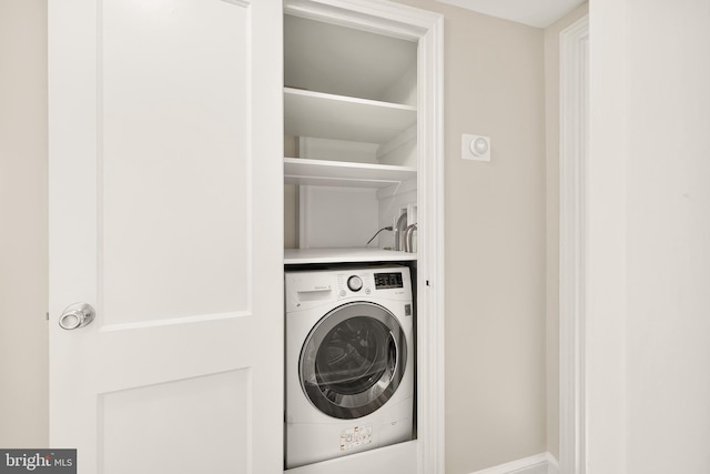 clothes washing area with washer / dryer