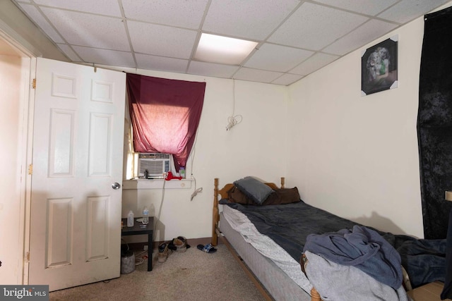 carpeted bedroom with a drop ceiling