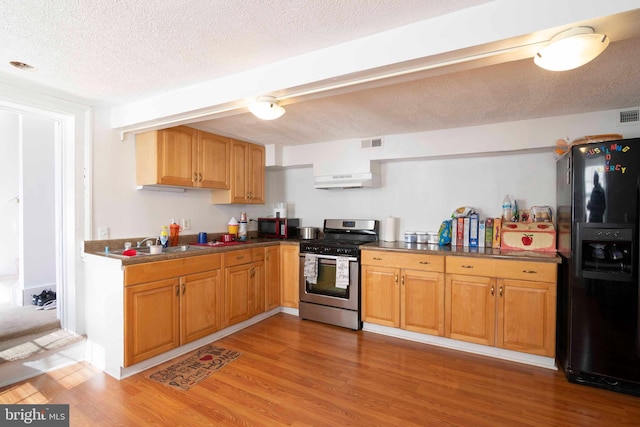 kitchen featuring a textured ceiling, hardwood / wood-style floors, and black appliances