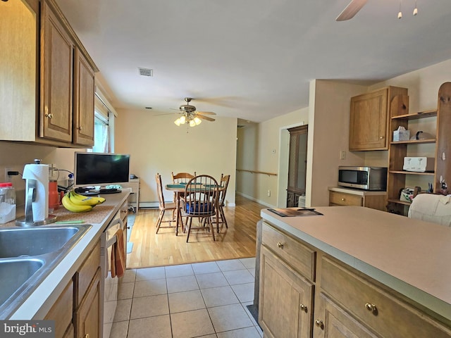 kitchen with appliances with stainless steel finishes, light tile patterned floors, and ceiling fan