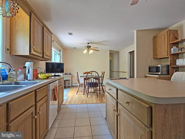 kitchen featuring stainless steel appliances, sink, light hardwood / wood-style floors, a center island, and ceiling fan