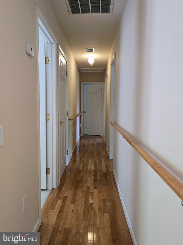 corridor with hardwood / wood-style flooring