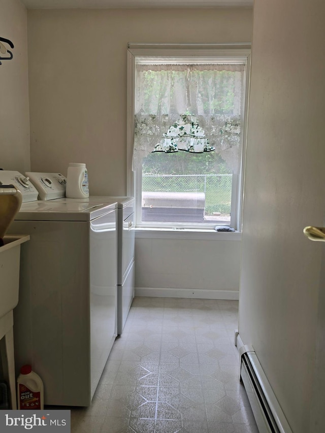 laundry area featuring a baseboard radiator, washer and dryer, a healthy amount of sunlight, and light tile patterned floors