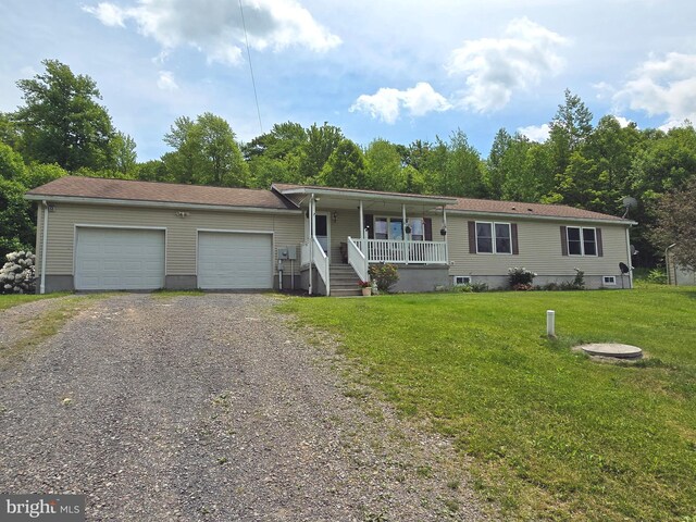 view of front of home featuring a garage, a front yard, and covered porch