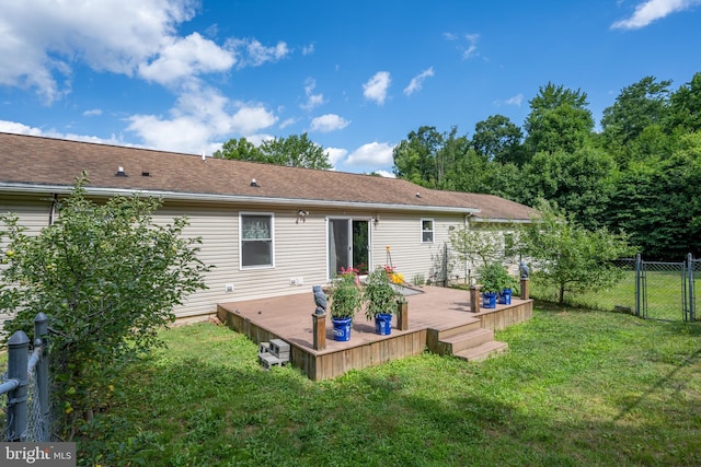 back of property with a wooden deck and a lawn