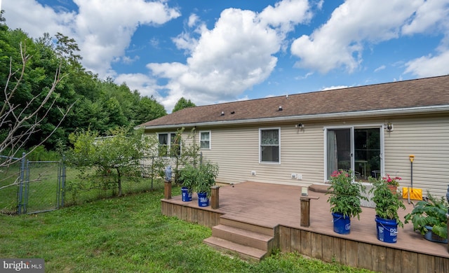 rear view of property with a yard and a wooden deck