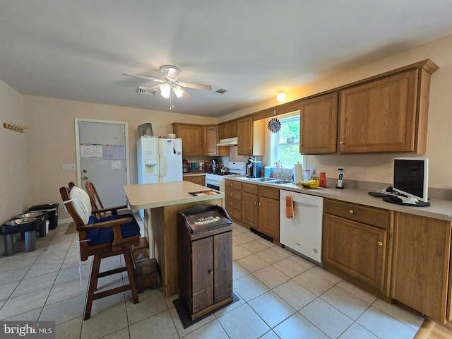 kitchen with light tile patterned flooring, white appliances, a center island, ceiling fan, and sink