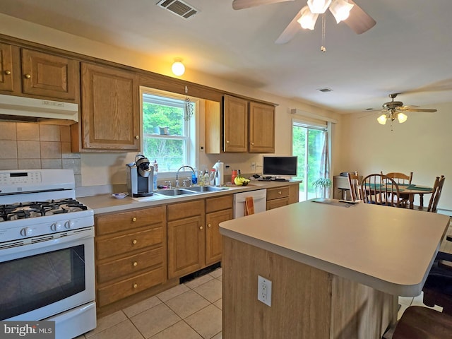 kitchen featuring white appliances, backsplash, plenty of natural light, light tile patterned flooring, and ceiling fan