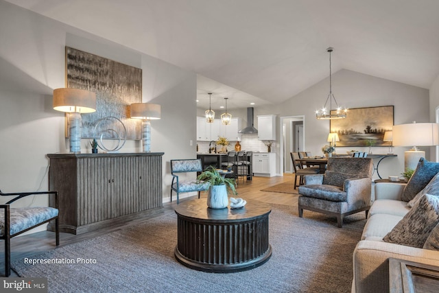 living room with hardwood / wood-style flooring, lofted ceiling, sink, and a chandelier