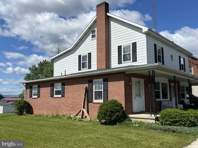 view of front of house featuring covered porch and a front lawn