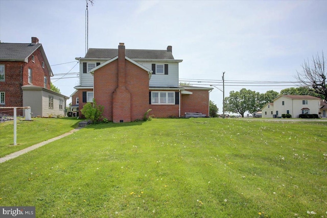 exterior space featuring a chimney, a front lawn, and brick siding