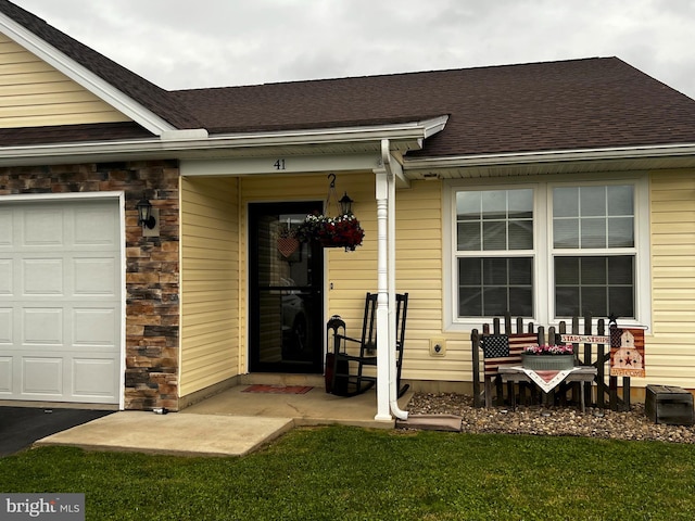 entrance to property with a garage and a yard