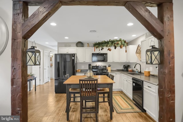 kitchen featuring black appliances, white cabinets, and light hardwood / wood-style floors