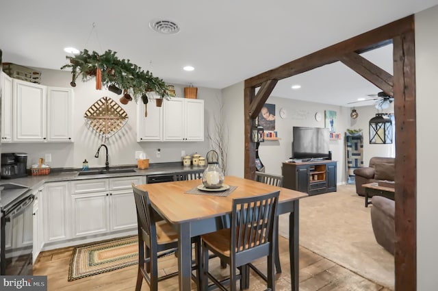 kitchen featuring ceiling fan, sink, and white cabinets