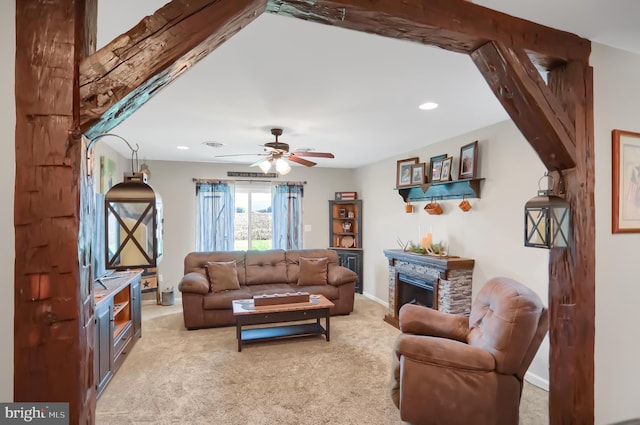 living room featuring carpet flooring, ceiling fan, and a fireplace